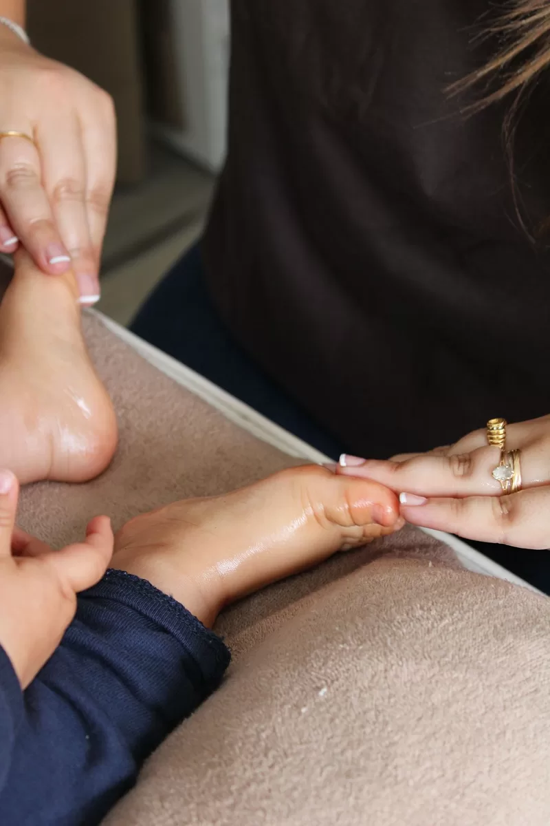 Gros plan d'une séance de réflexologie sur le pied d'un enfant